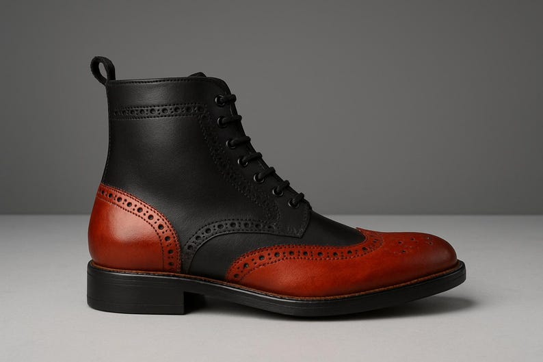 May include: A two-tone leather boot with a classic design. The upper is black, while the toe and heel counter are a rich reddish-brown. Features include brogue detailing and a lace-up closure. The boot has a sturdy black sole.