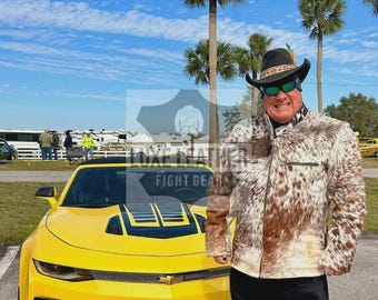 May include: A yellow sports car with black racing stripes and red accents is parked outdoors. A person wearing a brown and white cowhide jacket, black pants, and a cowboy hat stands next to the car. The text "FIGHT GEAR" is visible.
