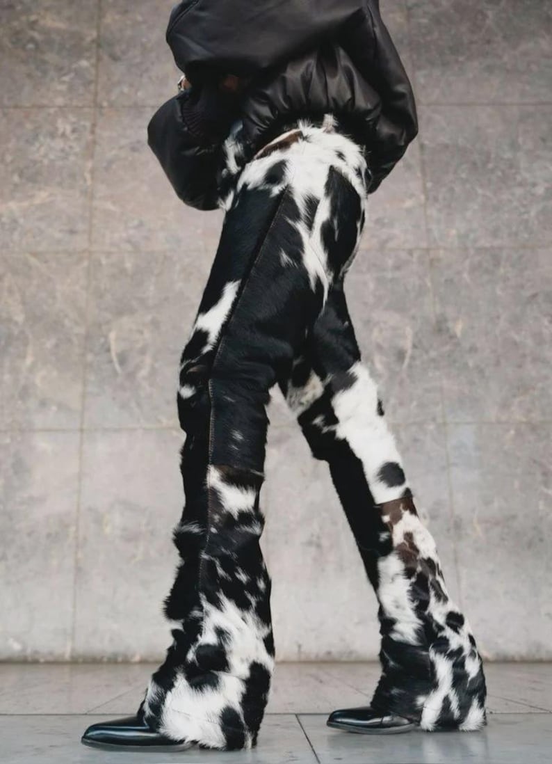Peut inclure: Pantalon &agrave; motif de peau de vache noir et blanc. Le pantalon est taille haute et &eacute;vas&eacute;. La mati&egrave;re est douce et textur&eacute;e. L'ensemble est compl&eacute;t&eacute; par des chaussures noires et une veste noire.