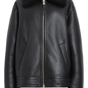 K&ouml;nnte beinhalten: Schwarze Lederjacke mit schwarzem Shearling-Kragen und -Manschetten. Die Jacke hat einen Frontrei&szlig;verschluss, zwei Seitentaschen und einen geraden Saum. Ein klassisches Oberbekleidungsst&uuml;ck.