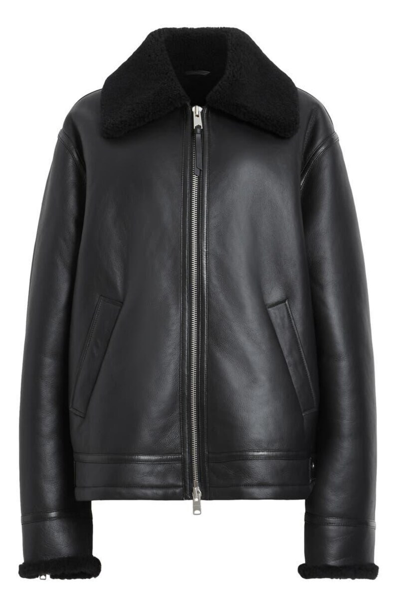 K&ouml;nnte beinhalten: Schwarze Lederjacke mit schwarzem Shearling-Kragen und -Manschetten. Die Jacke hat einen Frontrei&szlig;verschluss, zwei Seitentaschen und einen geraden Saum. Ein klassisches Oberbekleidungsst&uuml;ck.