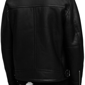 K&ouml;nnte beinhalten: Schwarze Lederjacke mit Shearling-Kragen. Die Jacke hat einen Rei&szlig;verschluss, eine Schnalle an der Taille und Rei&szlig;verschlussmanschetten. Die R&uuml;ckseite der Jacke hat ein klassisches Design mit vertikalen N&auml;hten.