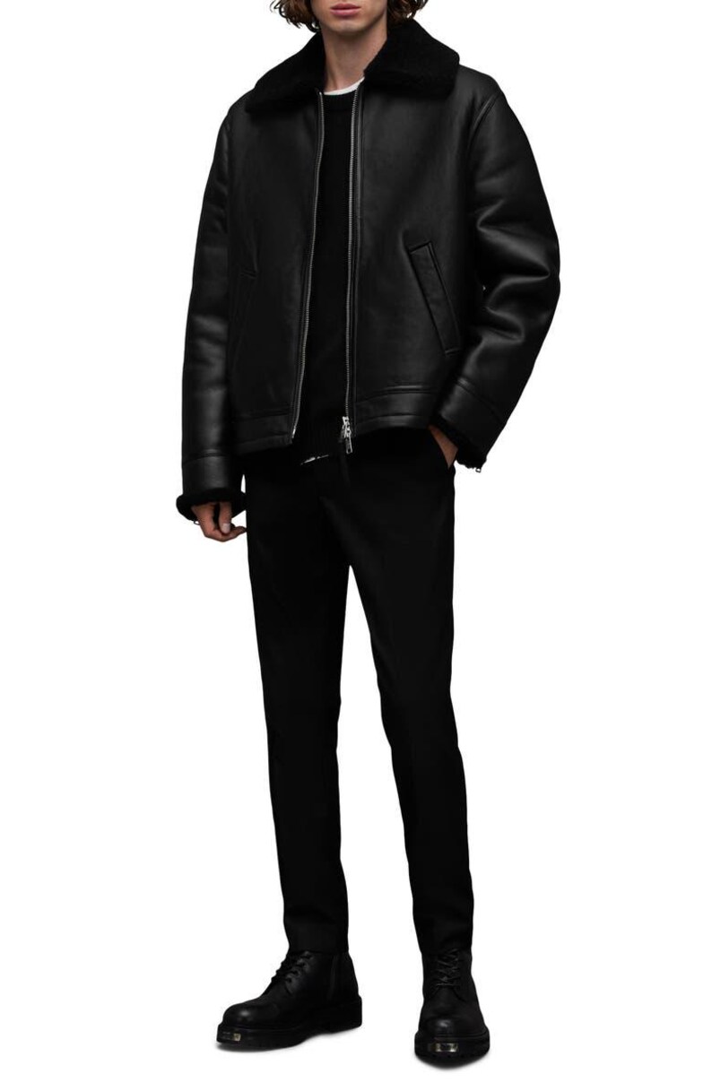 K&ouml;nnte beinhalten: Schwarze Lederjacke mit Shearling-Kragen, kombiniert mit schwarzer Hose und Stiefeln. Die Jacke hat einen Rei&szlig;verschluss vorne und ein klassisches Design. Ein komplettes Outfit f&uuml;r einen stilvollen Look.