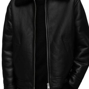 K&ouml;nnte beinhalten: Schwarze Lederjacke mit schwarzem Shearling-Kragen und -Futter. Die Jacke hat einen silbernen Rei&szlig;verschluss, zwei Vordertaschen und Shearling-Besatz an den Manschetten. Ein klassisches Oberbekleidungsst&uuml;ck.