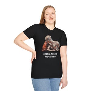 May include: Black t-shirt featuring a graphic of a metallic figure and a cat, with the text "KINDNESS NEEDS NO PROGRAMMING" in white. The shirt is made of a soft material and is suitable for casual wear.