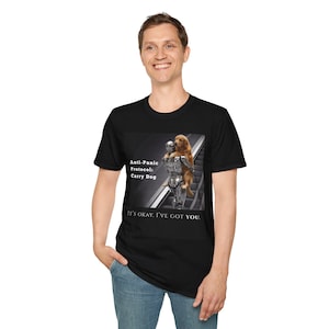 May include: Black t-shirt featuring a graphic of a robot carrying a golden retriever on an escalator. The text on the shirt reads "Anti-Panic Protocol: Carry Dog" and "IT'S OKAY. I'VE GOT YOU."
