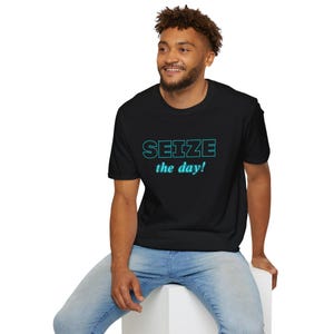 May include: A black short-sleeved t-shirt featuring the text SEIZE in a cyan outline font and the text the day! in a smaller cyan script font centered on the chest. The shirt has a crew neckline and a standard fit, providing a clean look.