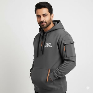 Personalised Logo Hoodies, Custom Logo Hoodie, Company Merch Jumpers, Custom Workwear Gift for Worker, Uniform Hoodie, Gift for Dad. May include: A charcoal gray hoodie with a front pocket, side pocket, and a zipper closure. The hoodie has the text "YOUR DESIGN" printed on the chest. The zipper pulls and pocket accents are brown.