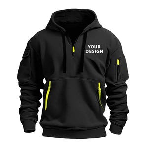 Personalised Logo Hoodies, Custom Logo Hoodie, Company Merch Jumpers, Custom Workwear Gift for Worker, Uniform Hoodie, Gift for Dad. May include: Black hooded sweatshirt with a half-zip closure and neon yellow accents on the pockets and zipper. The text "YOUR DESIGN" is printed on the chest. The sweatshirt has a kangaroo pocket and a small pocket on the left sleeve.