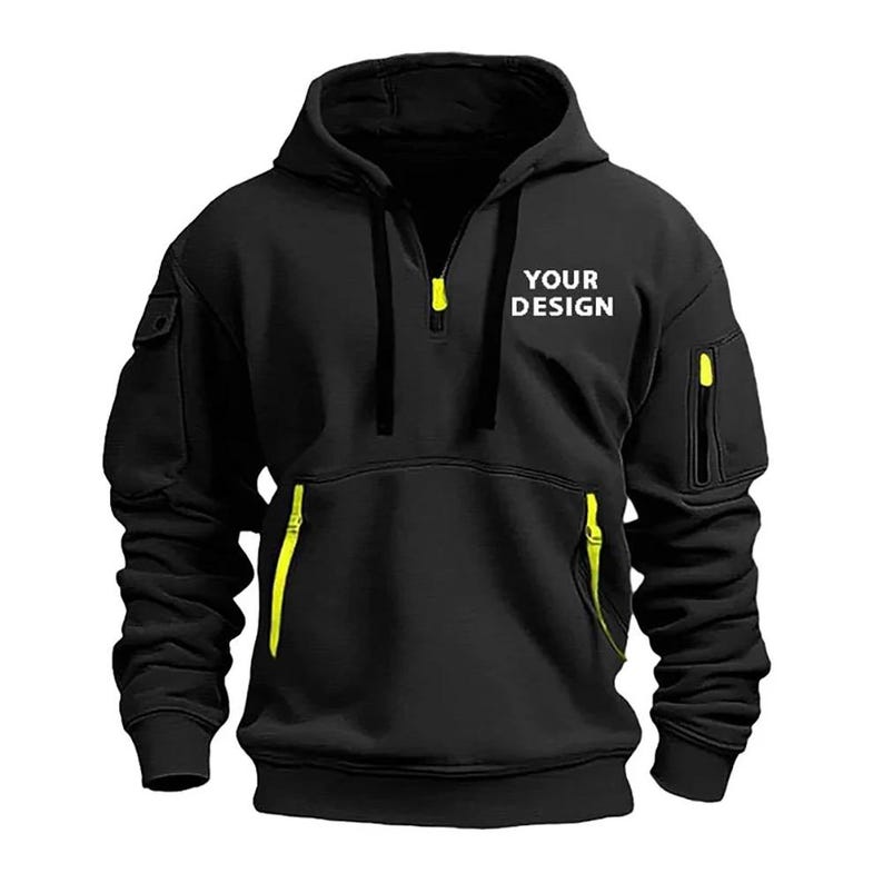 Personalised Logo Hoodies, Custom Logo Hoodie, Company Merch Jumpers, Custom Workwear Gift for Worker, Uniform Hoodie, Gift for Dad. May include: Black hooded sweatshirt with a half-zip closure and neon yellow accents on the pockets and zipper. The text "YOUR DESIGN" is printed on the chest. The sweatshirt has a kangaroo pocket and a small pocket on the left sleeve.