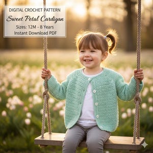 May include: A young child wearing a light green crocheted cardigan, sitting on a wooden swing. The cardigan has a button closure. The image includes the text "DIGITAL CROCHET PATTERN Sweet Petal Cardigan Sizes: 12M - 8 Years Instant Download PDF."
