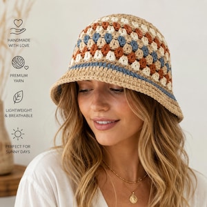 Puede incluir: Un sombrero de pescador de ganchillo con un diseño de patchwork. El sombrero presenta cuadrados de hilo beige, blanco, azul y óxido. Una banda azul acentúa el borde. Ligero y transpirable.
