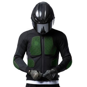 May include: Black motorcycle jacket with green protective padding on the chest, shoulders, and elbows. The jacket is zipped up and worn with a black helmet with a dark visor and gloves.