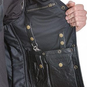 May include: Black leather vest with multiple pockets, snap closures, and a zipper. The vest has a satin lining and a key clip. The vest is designed with a classic biker style.