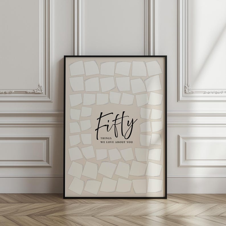 May include: A framed print with a beige background and a black border. The print features the word "Fifty" in elegant script, with the phrase "Things We Love About You" below. The background is filled with off-white, square shapes.