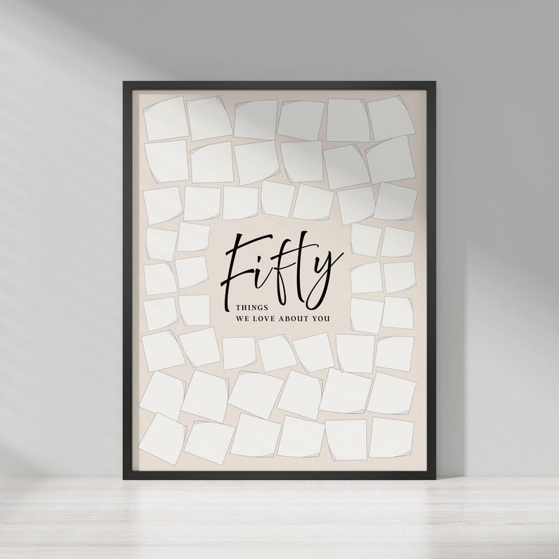 May include: A framed print with a beige background and a black border. The print features the word "Fifty" in elegant script, with the text "Things We Love About You" below. The background is filled with white, irregularly shaped squares.