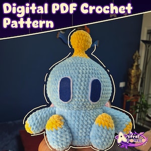May include: A light blue and yellow crocheted plush toy with large oval eyes and small arms and feet. The text "Digital PDF Crochet Pattern" is at the top of the image. The toy is handmade and has a soft, textured appearance.