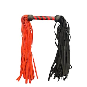 Puede incluir: Flogger negro y rojo. El mango negro tiene un diseño de rayas rojas y negras. Tiene dos juegos de tiras de cuero, uno rojo brillante y otro negro. Diseñado para juegos sensuales.