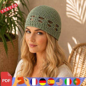 Peut inclure: Un bonnet en crochet vert sauge doté d'une calotte texturée et d'une bande décorative ajourée en forme de feuilles sur la partie inférieure. Le bonnet est réalisé en fil avec un point régulier et une finition mate et douce.