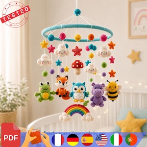 Peut inclure: Un mobile pour bébé en crochet avec un anneau bleu et des figurines suspendues : une grenouille verte, un renard orange, un hibou bleu, un hippopotame violet, une abeille jaune, des nuages blancs, des étoiles colorées, un champignon rouge et un arc-en-ciel.