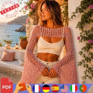 Peut inclure: Un boléro en crochet rose poudré avec un motif en maille ouverte et de longues manches évasées. Le vêtement est porté sur un haut court côtelé de couleur crème et un jean en denim clair, présentant une texture légère et ajourée.