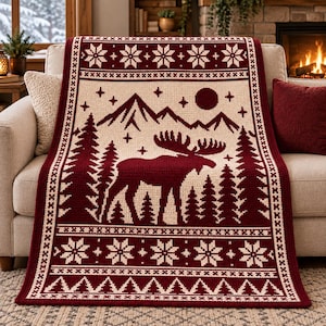 May include: A rectangular throw blanket featuring a two-tone maroon and cream color scheme. The design displays a central moose silhouette surrounded by pine trees, mountains, and a moon, framed by borders of geometric snowflake and chevron patterns.