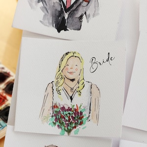 May include: Watercolor portraits of wedding guests, including a groom, bride, and mother, each with a name label. The bride holds a bouquet of flowers. The portraits are on white cards, with the names written in cursive.