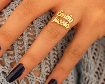 Peut inclure: Bague en or avec les noms "Emily" et "Jessica" superposés.