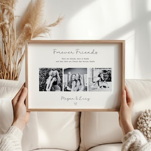 May include: A framed print with the words "Forever Friends" and three black and white photos. The print includes the names "Megan & Lucy" and a heart symbol. The frame is a light brown color.
