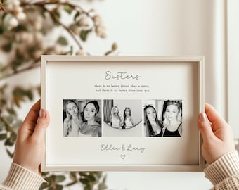 May include: A rectangular light-colored wooden frame containing a white print with the text Sisters, there is no better friend than a sister, and there is no better sister than you, three black and white photos, and the names Ellie & Lucy.