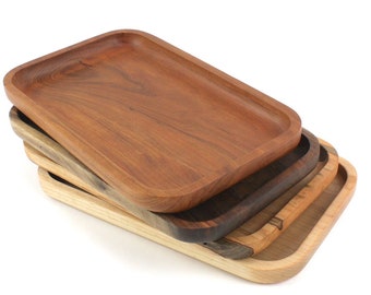 May include: Four wooden trays stacked on top of each other. The top tray is made of a light brown wood, the second tray is made of a darker brown wood, the third tray is made of a light brown wood, and the bottom tray is made of a light brown wood.