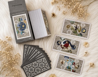 Könnte beinhalten: Ein Tarotkartendeck mit dem Titel WohStudios Exploration Yields Answers, bestehend aus einer grauen Schachtel, einem Kartenstapel und drei aufgedeckten Karten mit komplexen kreisförmigen Illustrationen. Ein Fächer aus Karten zeigt ein schwarz-weißes geometrisches Muster.