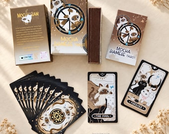 Könnte beinhalten: Ein Mocha Siamese Tarot-Deck mit einer Box mit Katzenillustration, einem Kartenstapel und einzelnen Karten mit Katzenmotiven. Die Karten enthalten Titel wie The Fool und Forever und sind in Braun-, Schwarz- und Weißtönen gehalten.