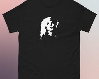 Puede incluir: Camiseta negra con un gráfico blanco del rostro de una mujer. El diseño es un retrato de alto contraste. La camiseta es de cuello redondo.