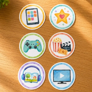 May include: Six circular stickers featuring watercolor illustrations: a tablet, a yellow star with a heart, a teal game controller, a popcorn bucket with a clapperboard and ticket, headphones over an open book, and a television screen with a play icon.