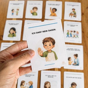 Puede incluir: Una tarjeta educativa rectangular blanca con una ilustración de dibujos animados de un niño de pelo castaño con una camiseta verde y blanca, levantando la mano en señal de stop, con el texto ICH DARF NEIN SAGEN impreso en negro arriba.