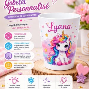 Peut inclure: Un gobelet blanc en plastique orné d'une illustration colorée de licorne avec une crinière arc-en-ciel et une corne dorée. Le prénom Lyana est inscrit en écriture rose au-dessus. Le gobelet est décoré de petits cœurs roses et d'étoiles jaunes.