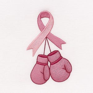 May include: Pink boxing gloves hang from a pink ribbon, embroidered on a white background. The gloves are a darker shade of pink with red trim. The ribbon is a lighter shade of pink.