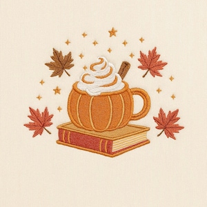 Puede incluir: Imagen bordada de una taza con forma de calabaza llena de crema batida y una ramita de canela, apoyada sobre un libro. Alrededor de la taza hay hojas de otoño y estrellas, todo en cálidos colores otoñales.