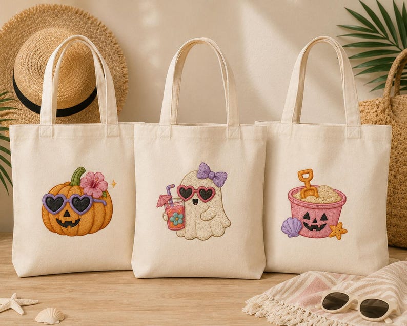 May include: Three off-white canvas tote bags with Halloween-themed designs. One features a pumpkin with heart-shaped sunglasses, another a ghost with heart-shaped sunglasses, and the last a sand pail with a jack-o'-lantern face.