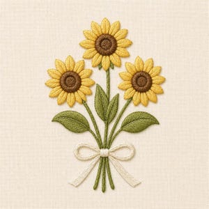 May include: Embroidered bouquet of three sunflowers with yellow petals and brown centers, green stems and leaves, and a white ribbon. The floral arrangement is on a cream-colored fabric background.