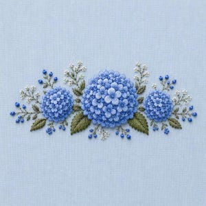 May include: Embroidered floral design featuring three blue hydrangea blooms with detailed stitching. The arrangement includes green leaves, small white flowers, and blue berry accents, all set against a light blue fabric background.