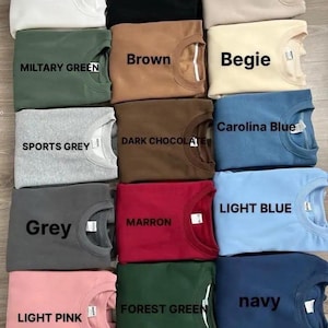 Puede incluir: Una cuadr&iacute;cula de sudaderas de cuello redondo en varios colores, incluyendo blanco, negro, arena, verde militar, marr&oacute;n, beige, gris deportivo, chocolate oscuro, gris, granate, azul claro, rosa claro, verde bosque y azul marino. Cada sudadera tiene el nombre del color impreso.