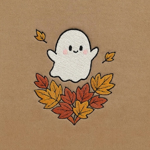 Op de afbeelding: Geborduurd ontwerp van een vriendelijk wit spookje met roze wangen, omringd door herfstbladeren in oranje, gele en rode tinten. Het ontwerp staat tegen een bruine achtergrond, wat een herfst- of Halloween-thema oproept.