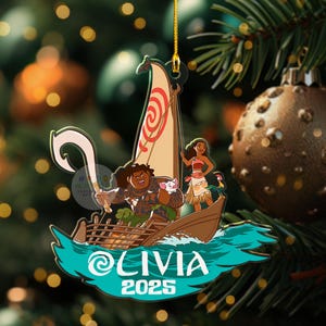 May include: A Christmas ornament featuring characters from the animated film Moana. The ornament depicts a boat with characters, including Maui, Moana, and Pua, sailing on turquoise waves. The name "OLIVIA" and the year "2025" are displayed on the ornament.