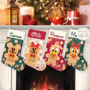May include: Four Christmas stockings hang above a fireplace, each with a different gingerbread character design. The stockings are green, red, and white, with names embroidered on the top. A Christmas tree and decorations are in the background.