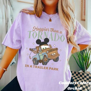 May include: A white ceramic mug with a black handle and the text "But First, Coffee" in a bold, black font. The mug is set against a neutral background, highlighting its simple design.