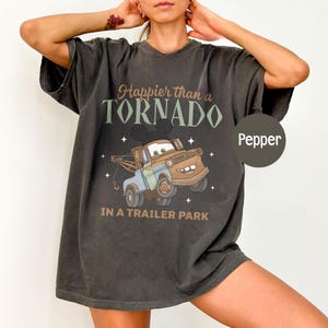 May include: A white ceramic mug with a black handle and the text "But First, Coffee" in a black, handwritten-style font. The mug is on a white surface.