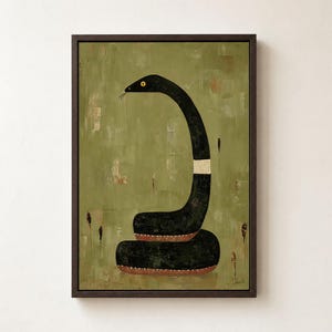 May include: A framed wall art print featuring a black snake with a white band and a yellow eye, positioned against a textured olive green background. The snake has a reddish-brown base and small, thin, vertical brown markings scattered around.