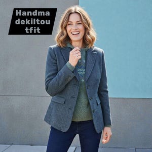 May include: A woman in a blue blazer, green sweater, and dark blue jeans. The blazer has a textured pattern and three buttons. The text "Handma dekilton tfit" is in a black box in the upper left corner.